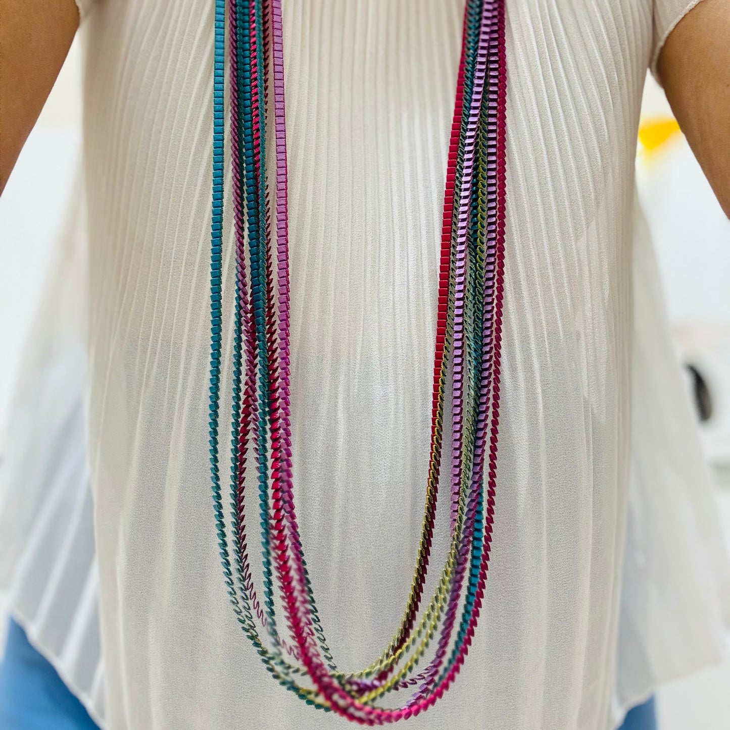 una donna che indossa una camicia bianca e una collana multicolore