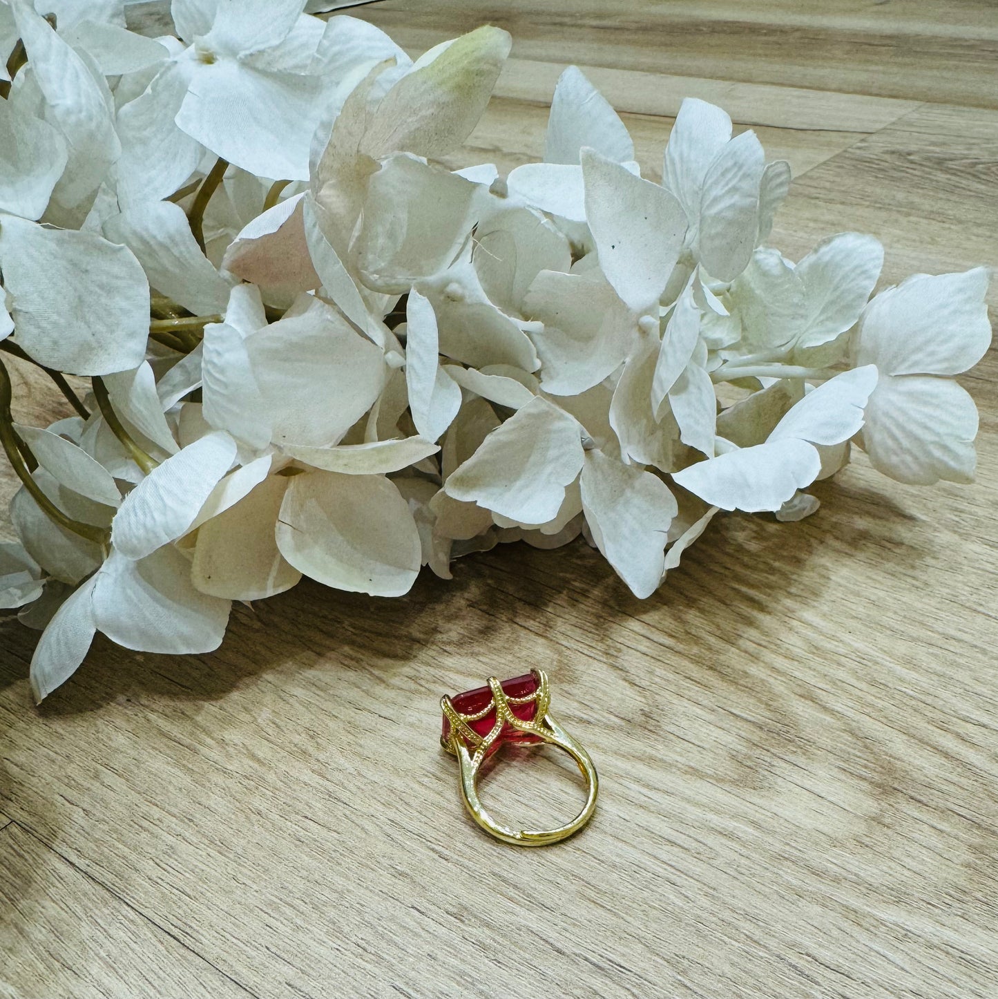 un primo piano di un fiore e di un anello su un tavolo