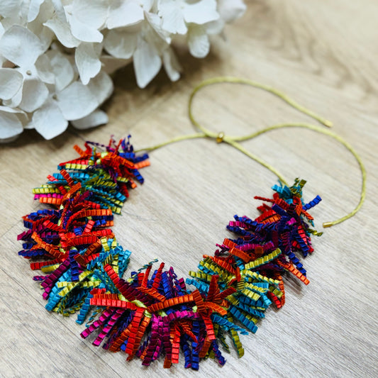 una collana multicolore posata su un tavolo di legno