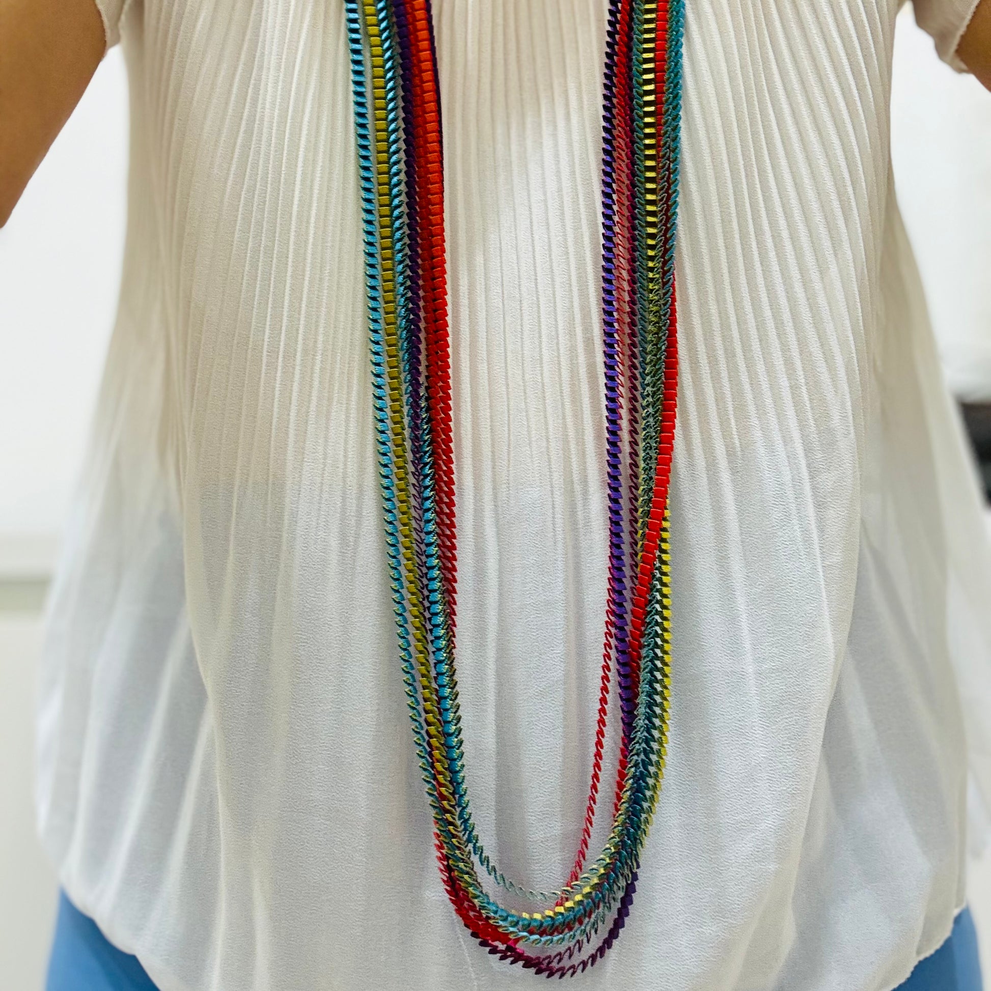 una donna che indossa una camicia bianca e una collana multicolori