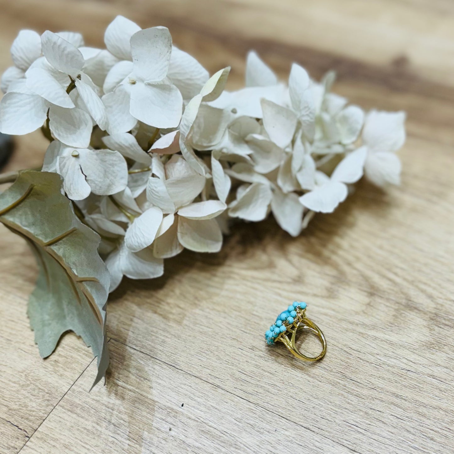 un anello appoggiato su un tavolo accanto a dei fiori