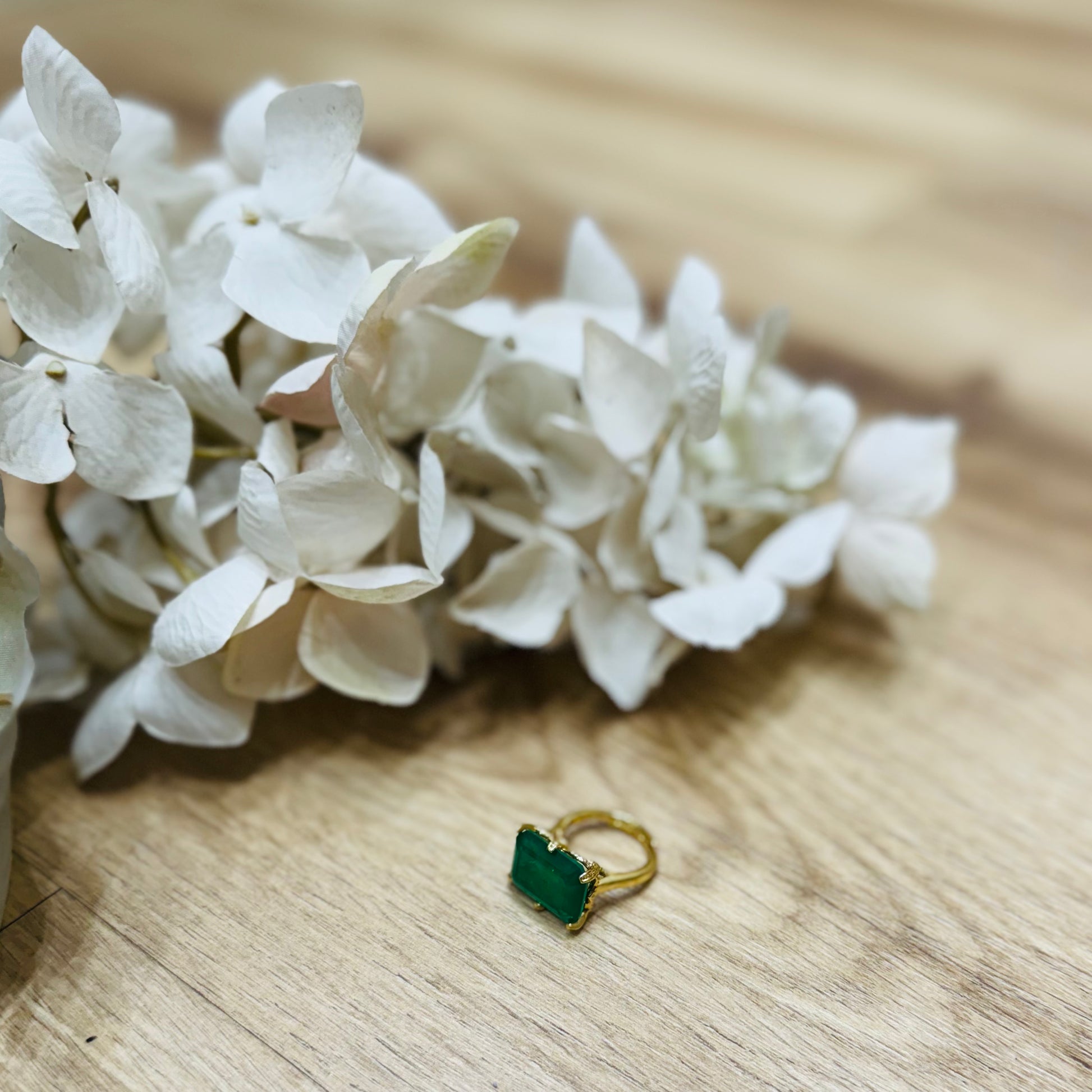 un anello verde posato su un tavolo di legno