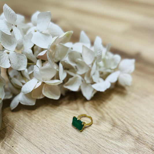 un anello verde posato su un tavolo di legno