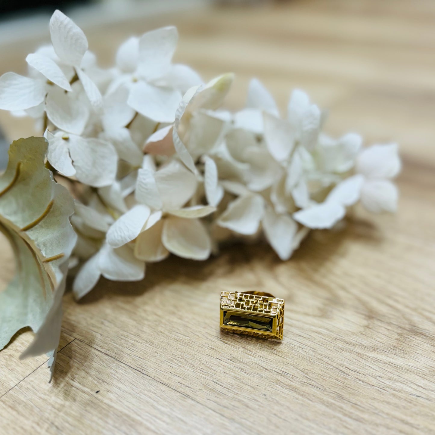 una vista ravvicinata di un fiore su un tavolo con vicino un anello
