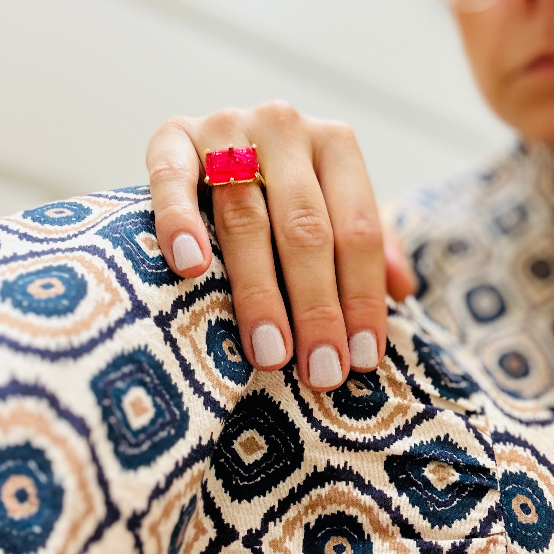 la mano di una donna con un anello rosso sul dito