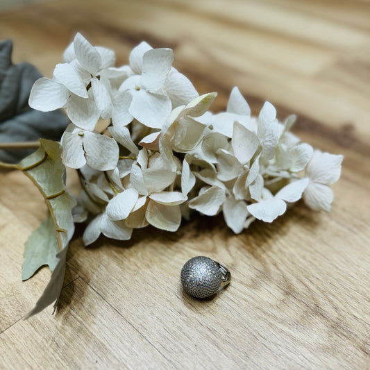 un primo piano di un fiore ed un anello su un tavolo