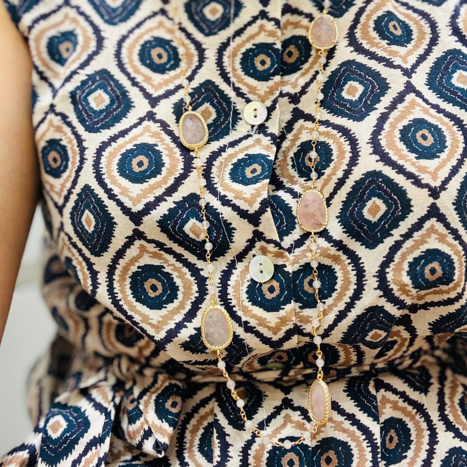 un primo piano di una donna che indossa un vestito fantasioso ed una collana