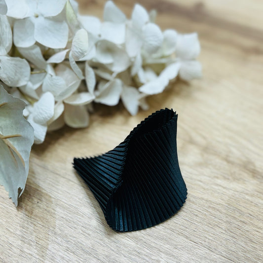 un primo piano di un fiore su un tavolo con un braccialetto nero