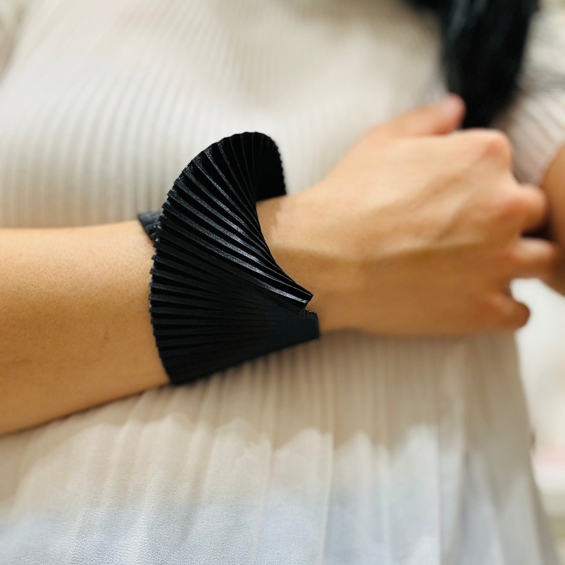 un primo piano di una persona che indossa un bracciale nero